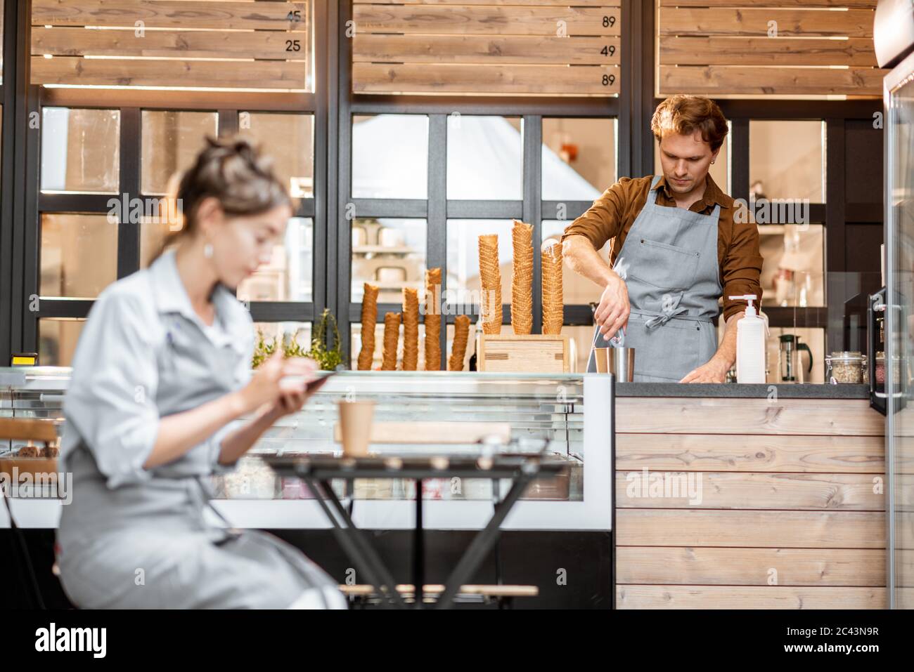 Das Personal im Café oder in der Konditorei, der Kellner am Telefon und der Verkäufer arbeiten am Ladentisch Stockfoto