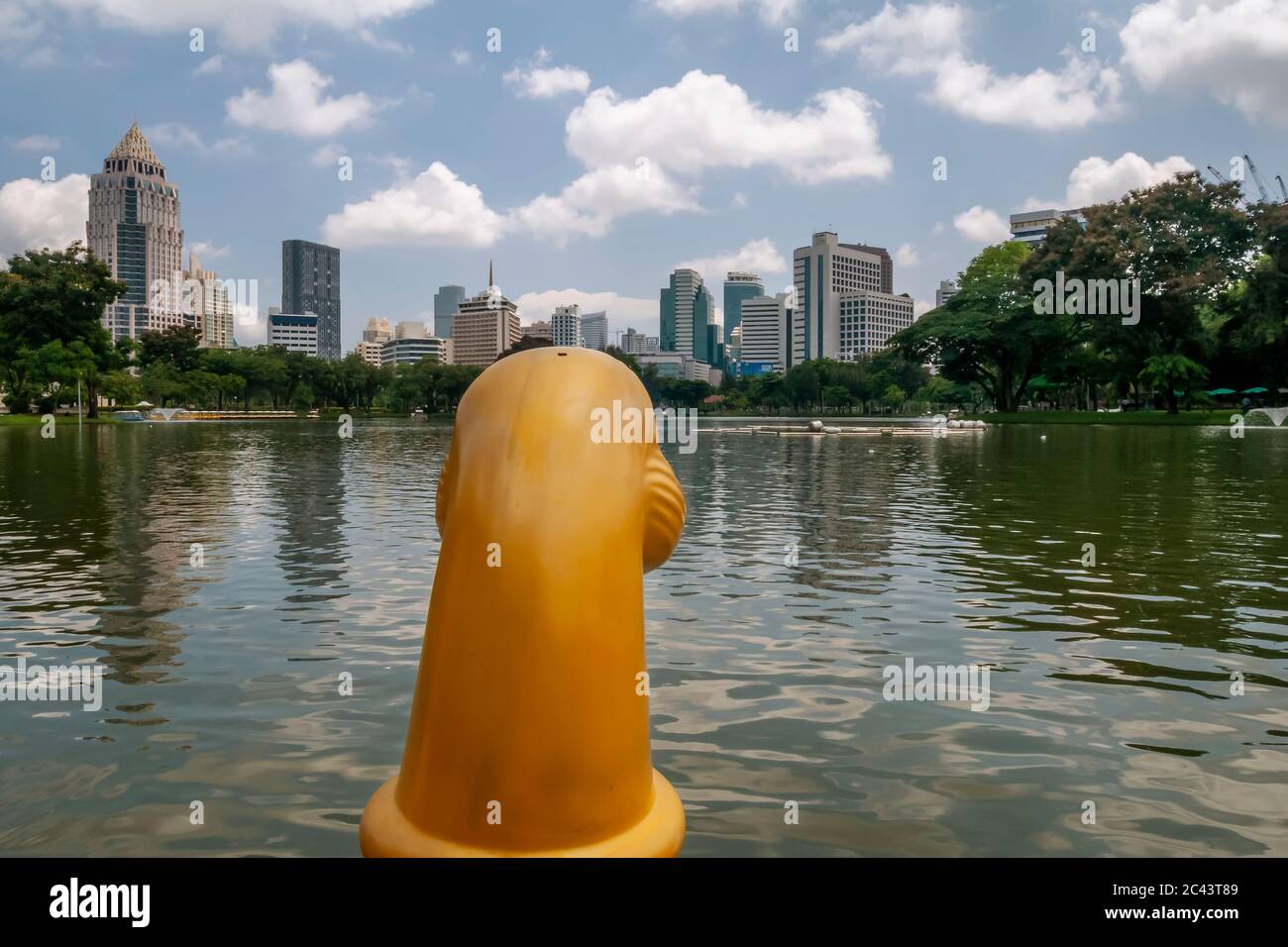 Bootsfahrt auf einem See im Lumphini Park in Bangkok, Thailand, mit den Wolkenkratzern der Rama IV Road im Hintergrund Stockfoto