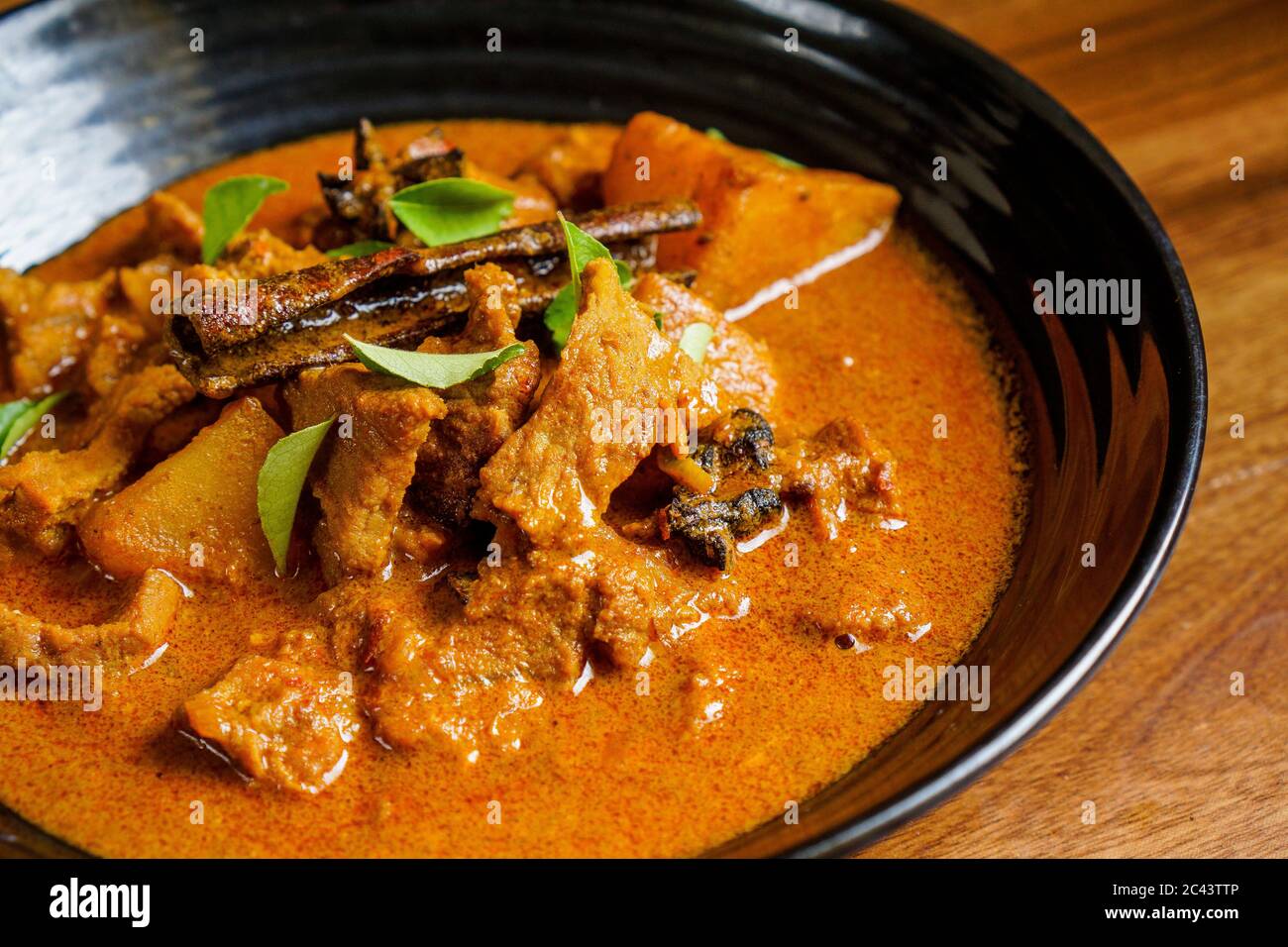 Lammfleisch in dickem Curry mit Kartoffeln und Gewürzen gekocht und mit Curryblättern garniert. Stockfoto
