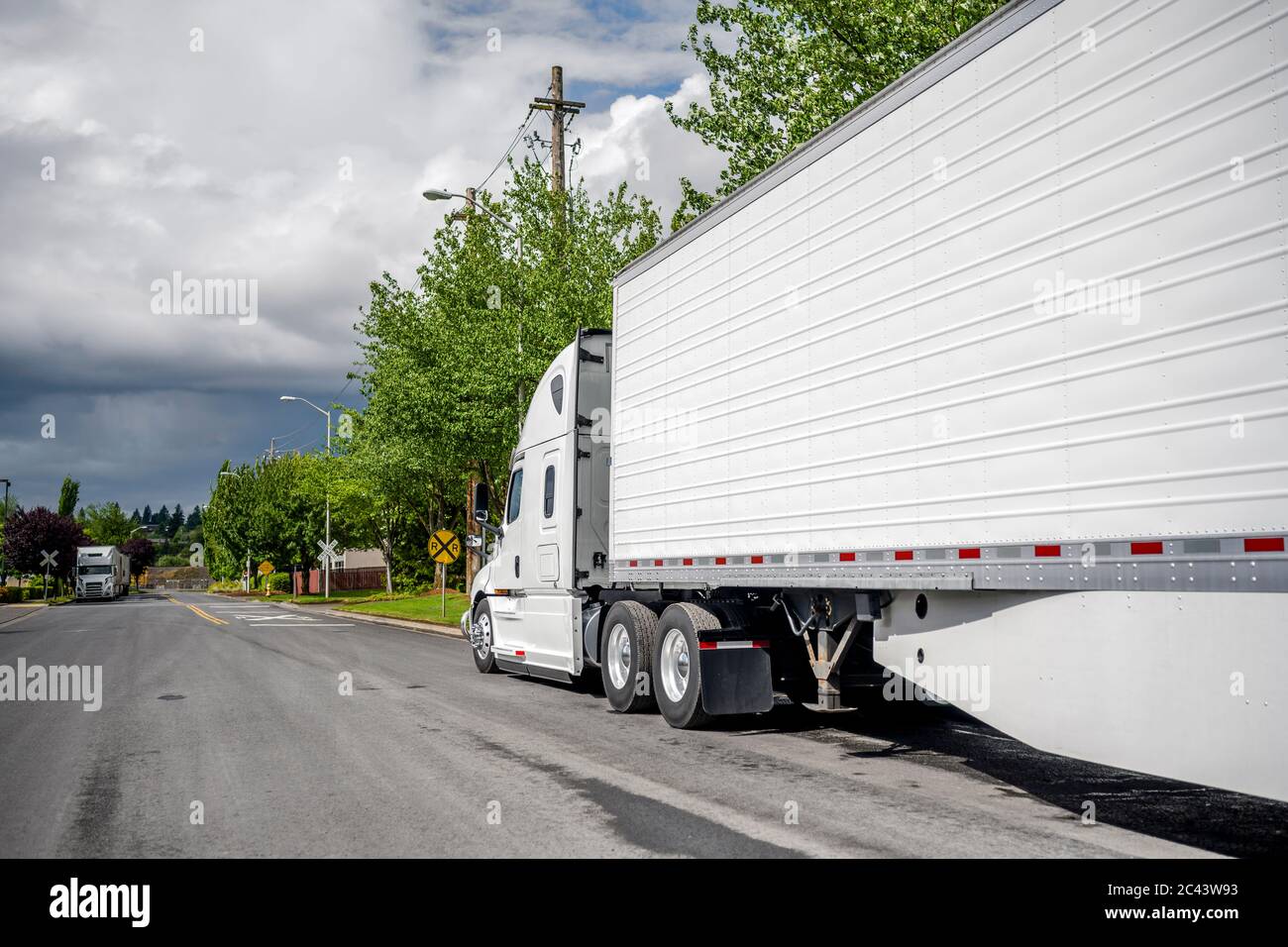 Große Rig Langstrecke Industriefracht weißen Semi-Truck mit Kühlergrill Guard und Kühlschrank semi Trailer mit Rock warten auf kommerzielle Fracht geparkt o Stockfoto