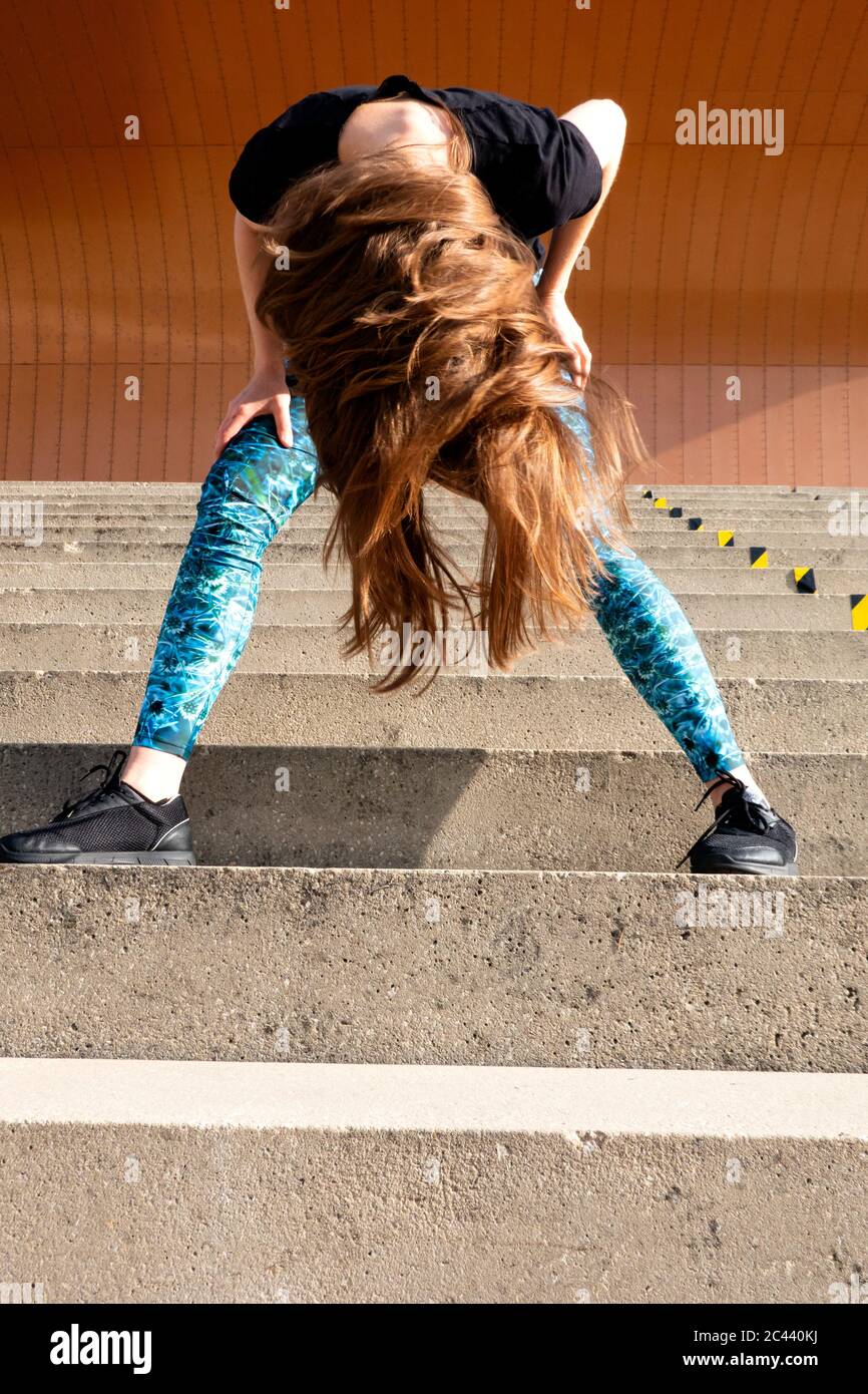 Sorgloser Fitnesstrainer schüttelt den Kopf während er auf der Treppe steht Stockfoto