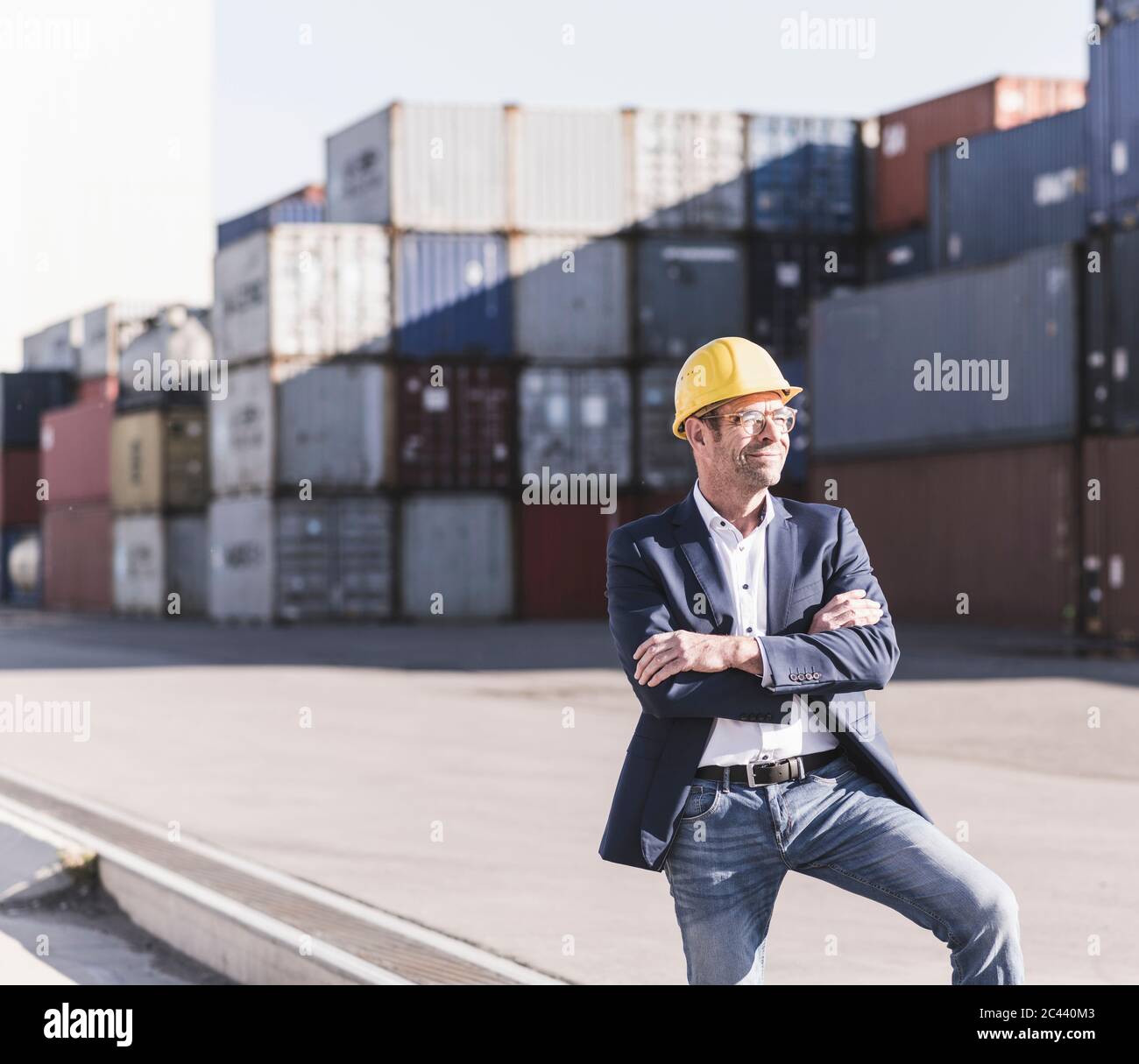 Porträt eines lächelnden Geschäftsmannes mit Schutzhelm auf dem Industriegelände Stockfoto