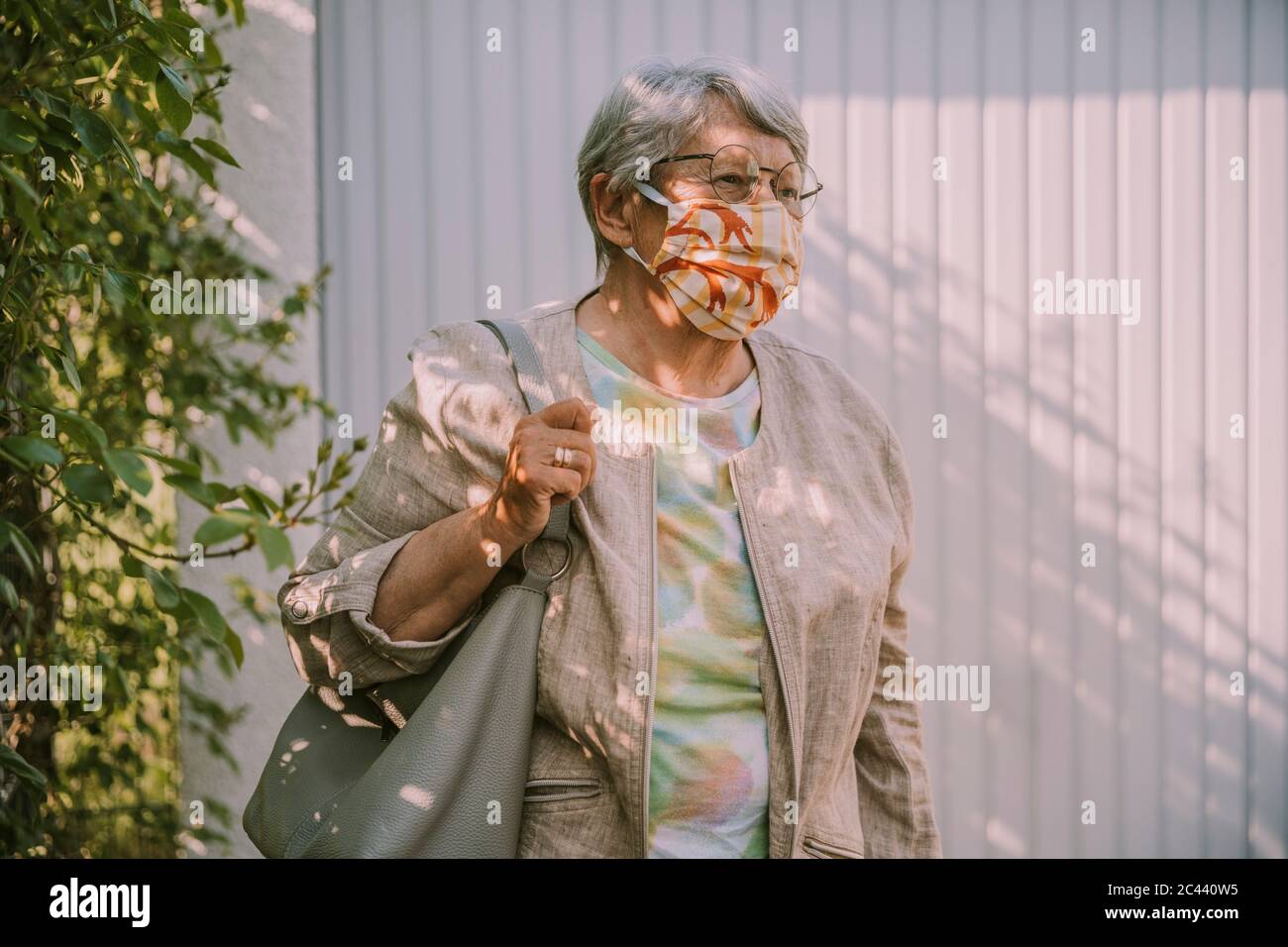 Ältere Frau trägt Gesichtsmaske beim Gehen im Freien während Pandemie Ausbruch Stockfoto