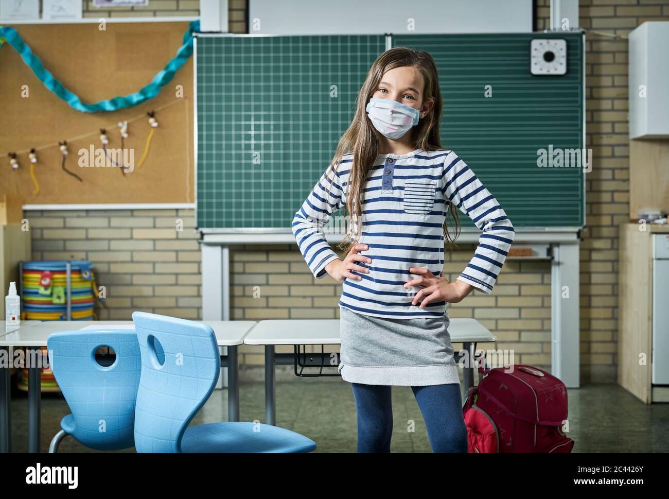 Portrait von selbstbewussten Mädchen tragen Maske im Klassenzimmer Stockfoto