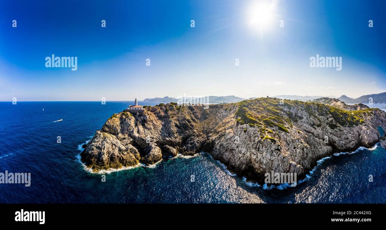 Spanien, Mallorca, Cala Ratjada, Helikopter Blick auf die Sonne scheint über Küstenklippen und Far de Capdepera Leuchtturm im Sommer Stockfoto
