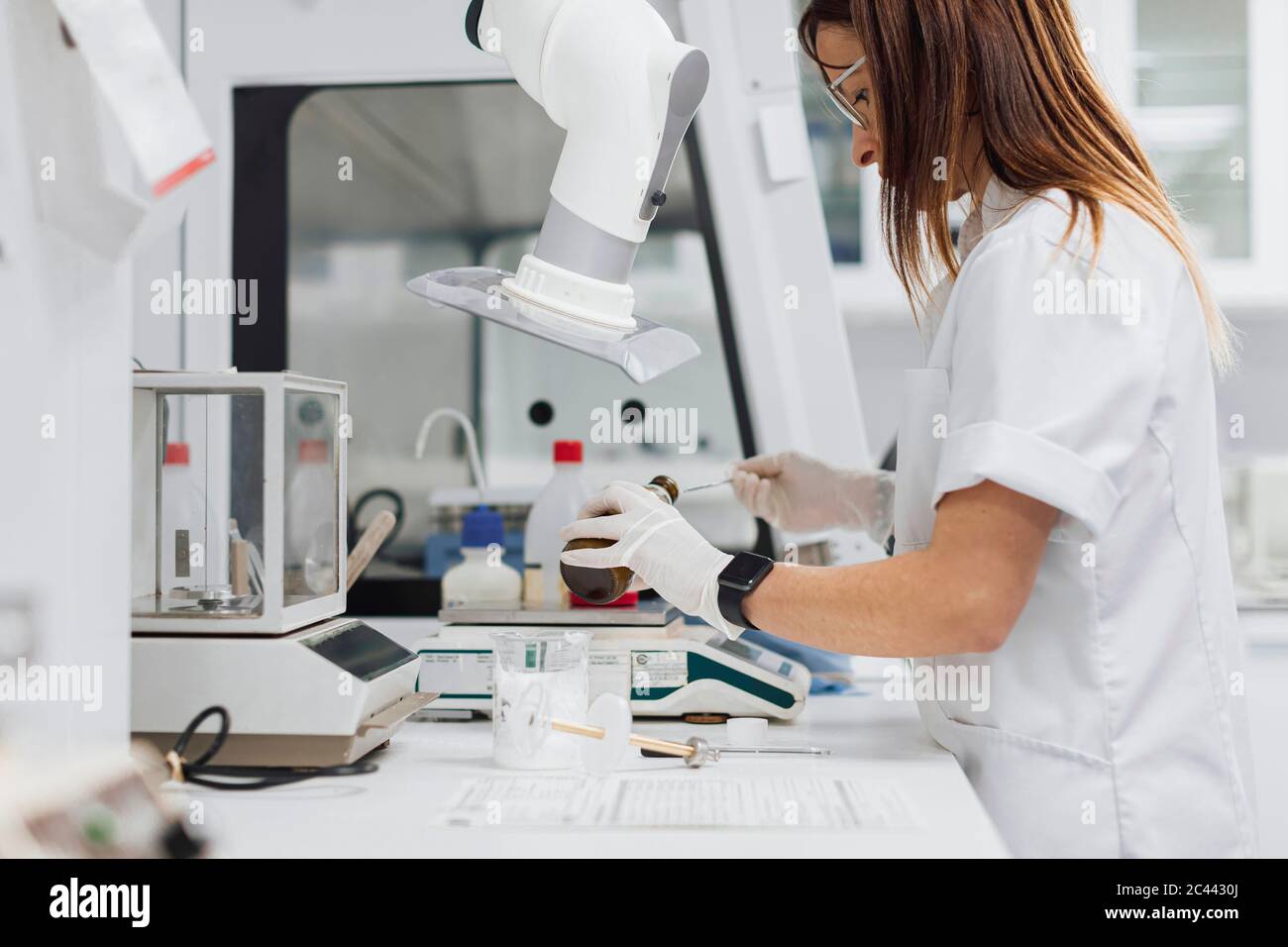 Reife weibliche Arzt Entfernen von Medikamenten aus der Flasche, während Forschung im Labor Stockfoto