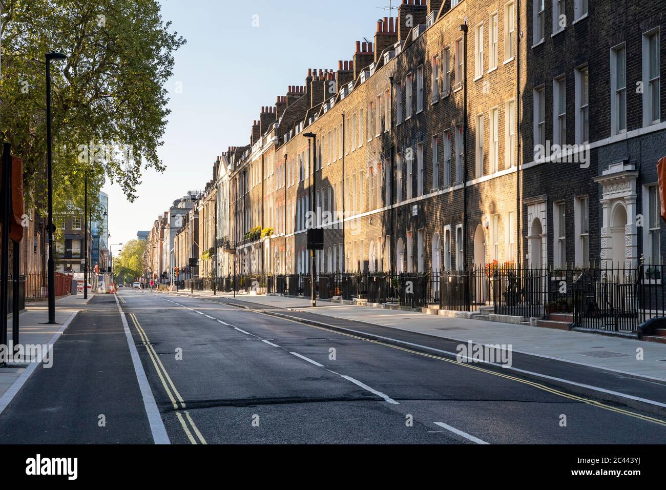 Großbritannien, London, Schatten auf Ziegelsteingebäude in leerer Straße Stockfoto
