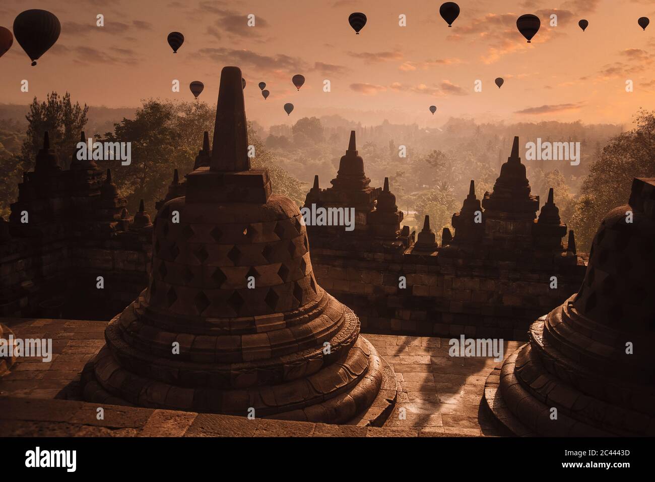 Indonesien, Zentral-Java, Magelang, Silhouetten von Heißluftballons, die in der Dämmerung über dem Borobudur-Tempel fliegen Stockfoto