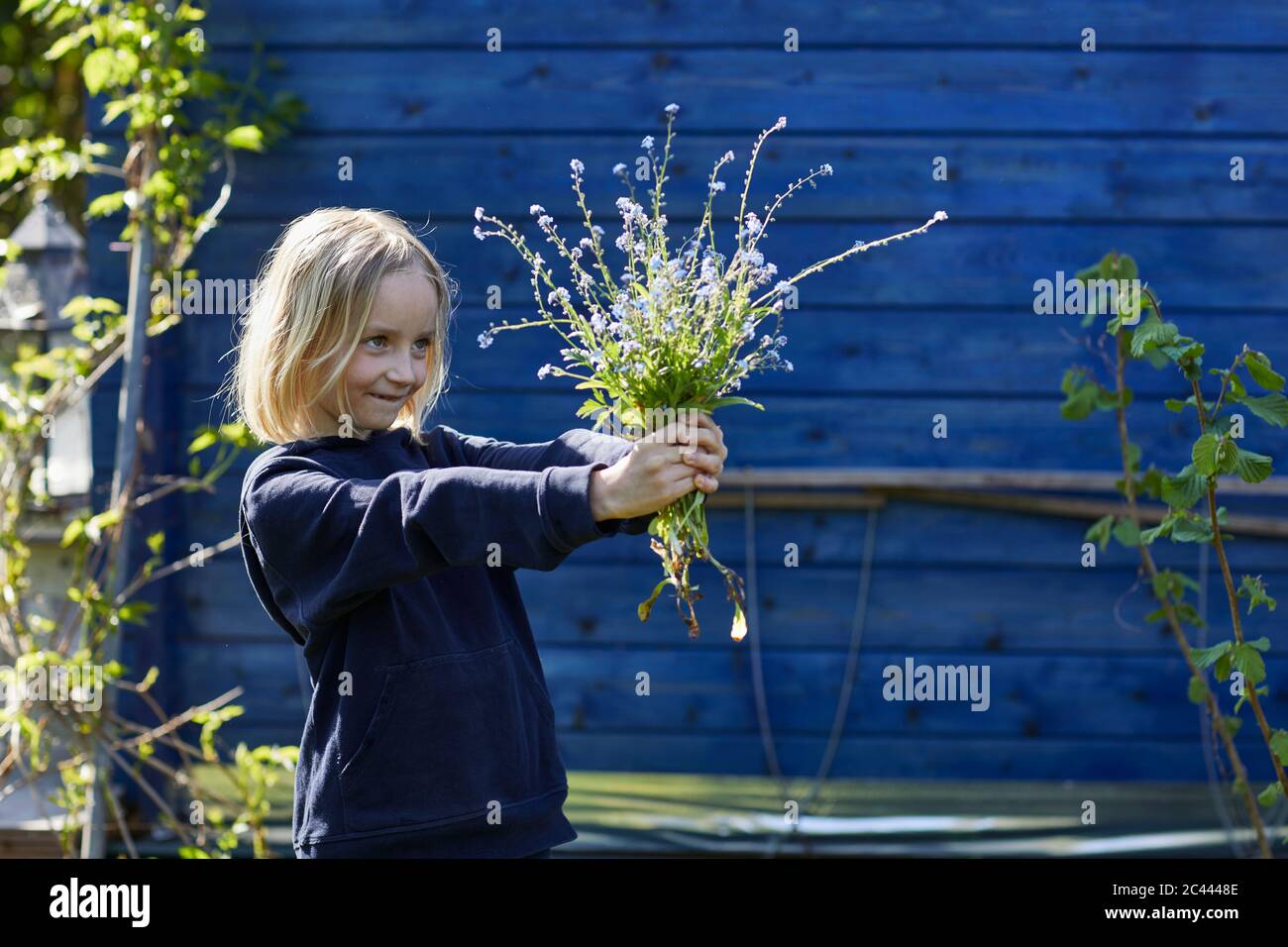 Portrait eines Mädchens in Schrebergarten mit Blumenstrauß Stockfoto