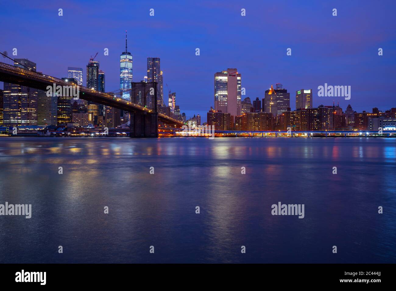 USA, New York, New York City, East River und Brooklyn Bridge bei violetter Dämmerung mit Manhattan Skyline im Hintergrund Stockfoto
