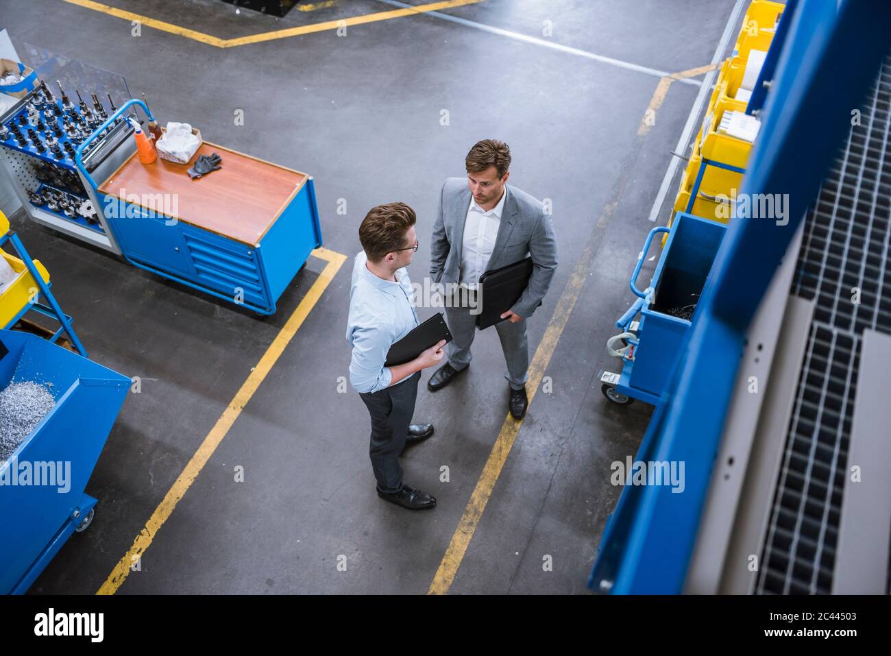 Draufsicht auf zwei Geschäftsleute, die in der Fabrik sprechen Stockfoto