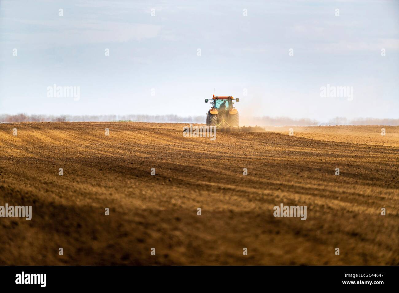 Landwirt im Traktor Pflügen Feld im Frühjahr Stockfoto