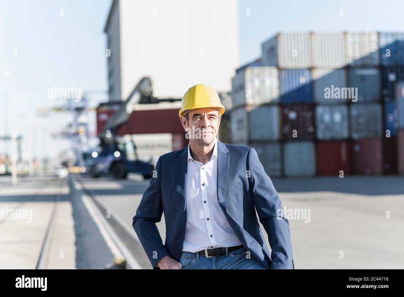 Porträt eines Geschäftsmannes mit Schutzhelm auf dem Industriegelände Stockfoto