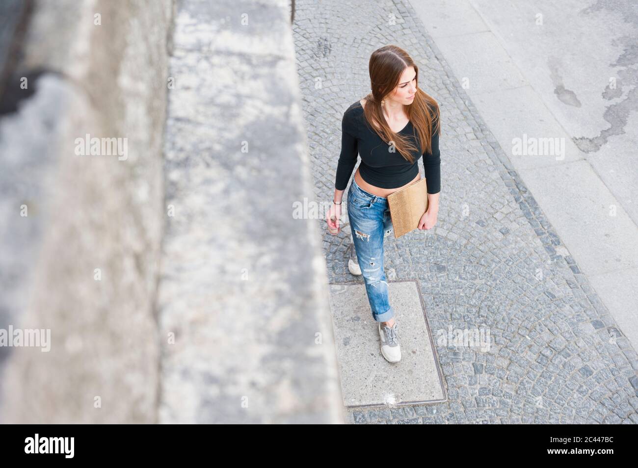 Modische Frau, die auf dem Bürgersteig in der Stadt läuft Stockfoto