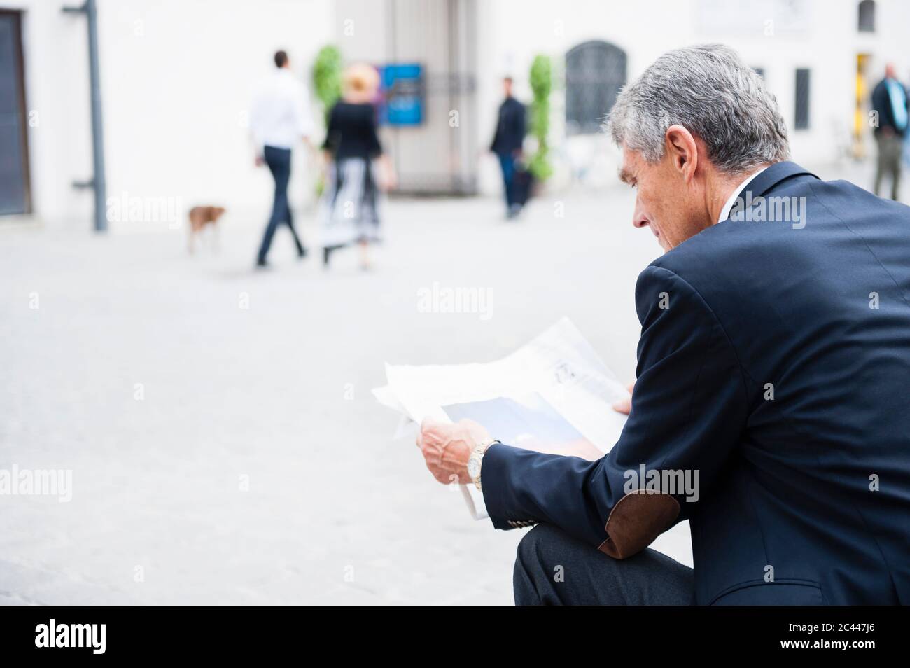 Senior Geschäftsmann liest Zeitung im Freien Stockfoto