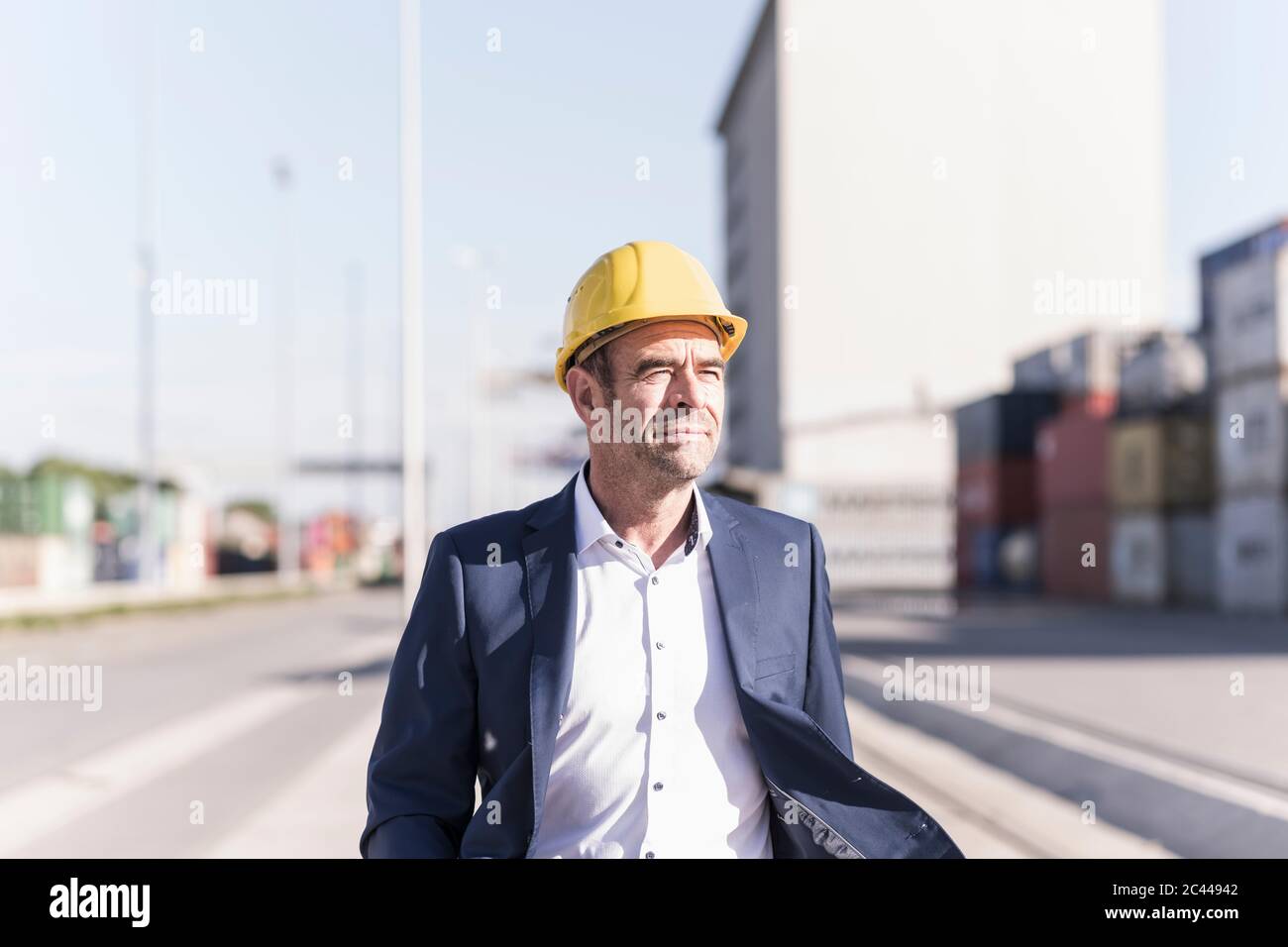Porträt eines Geschäftsmannes mit Schutzhelm auf dem Industriegelände Stockfoto