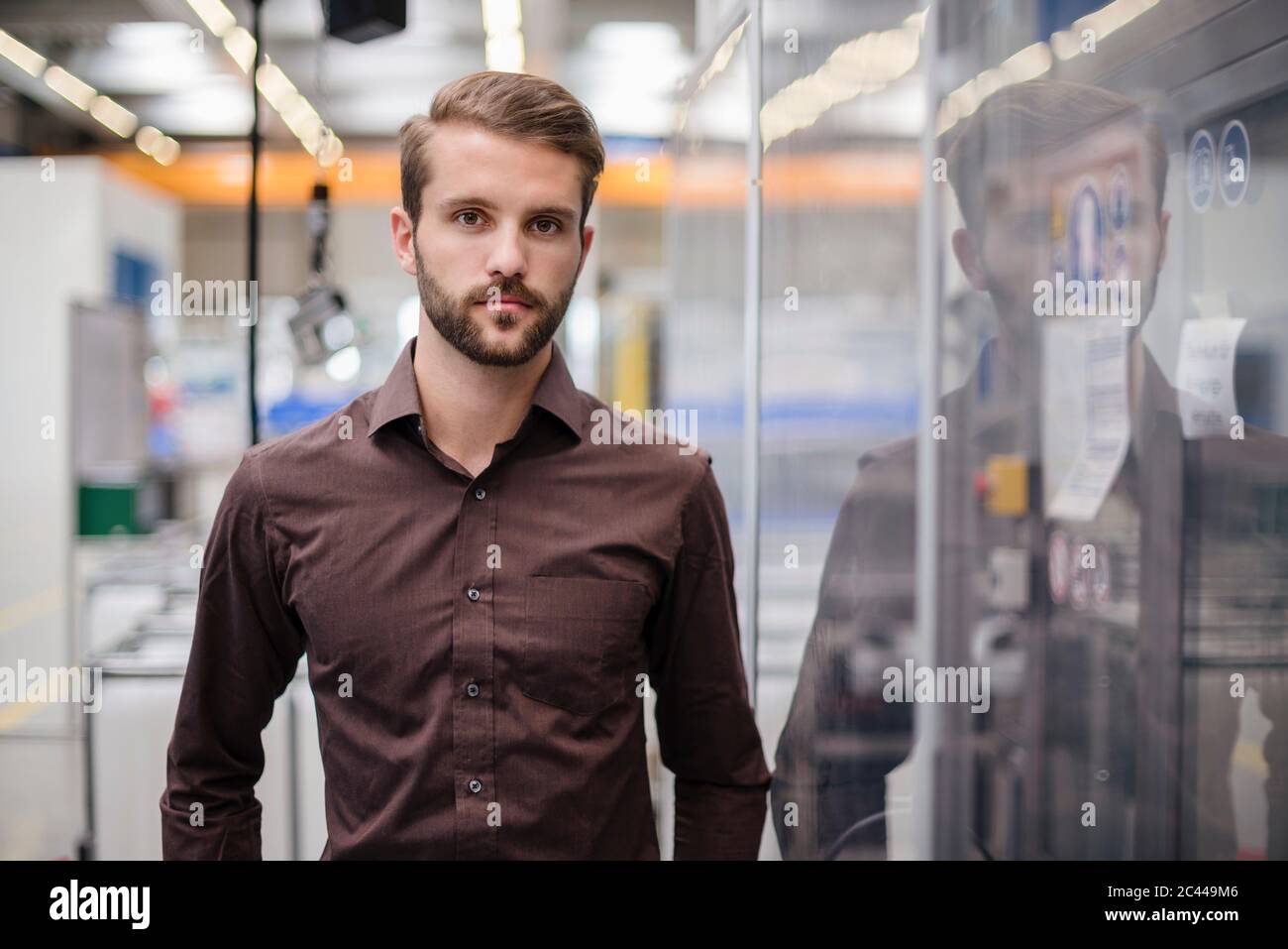 Porträt eines ernsthaften jungen Geschäftsmannes in einer Fabrik Stockfoto