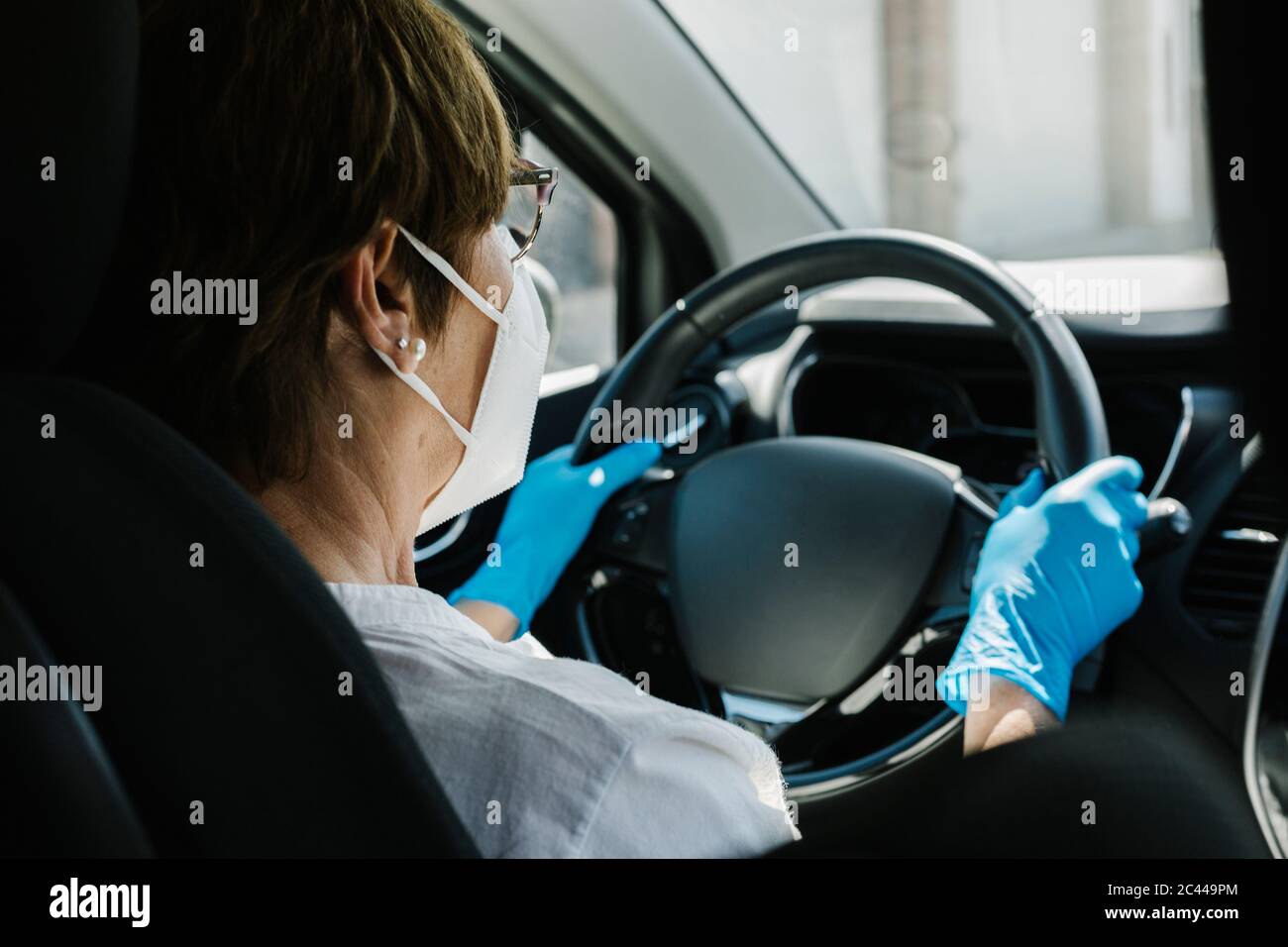 Frau trägt Maske und Handschuhe Auto fahren Stockfotografie - Alamy