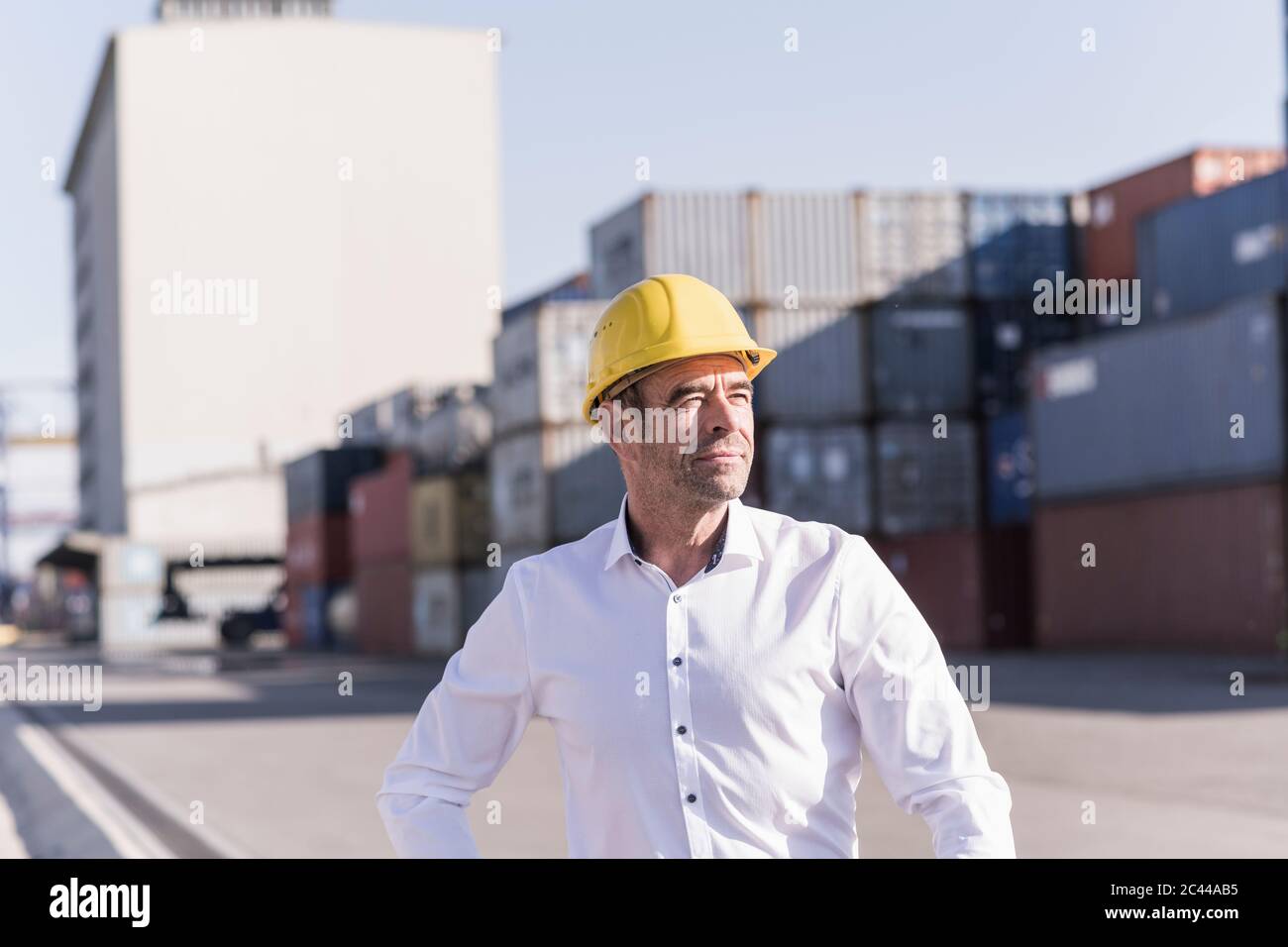 Porträt eines Geschäftsmannes mit Schutzhelm auf dem Industriegelände Stockfoto