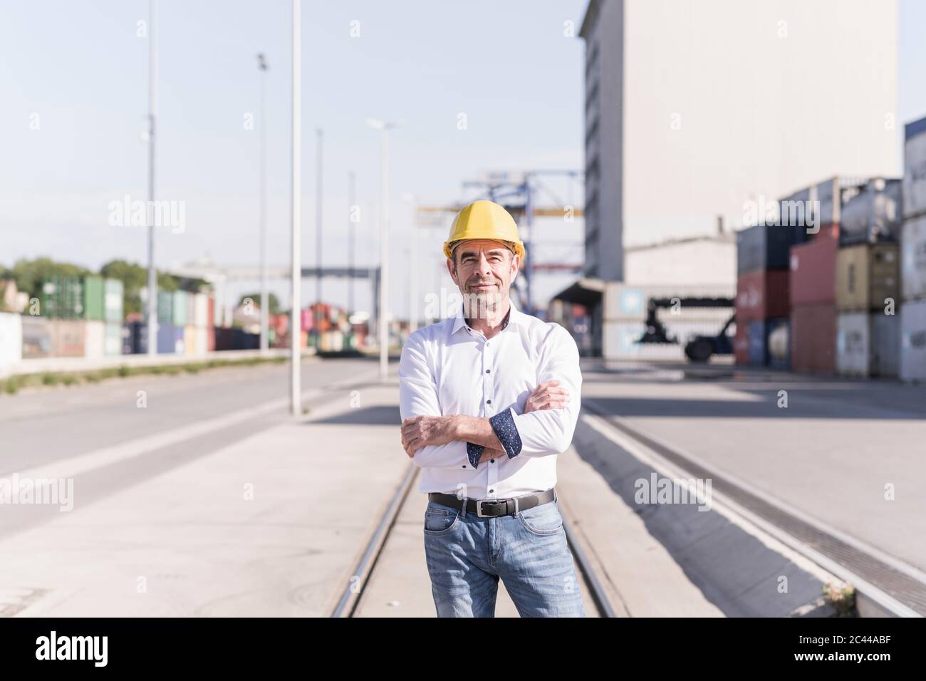 Porträt eines Geschäftsmannes mit Schutzhelm vor der Industrieanlage Stockfoto