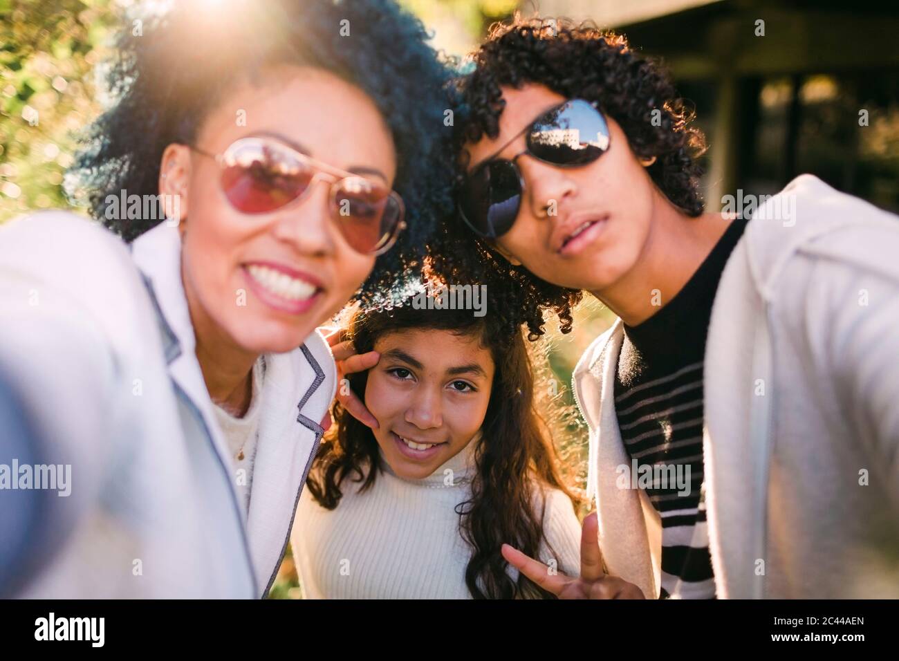 Mutter und Sohn tragen Sonnenbrille, während sie mit Mädchen im Park stehen Stockfoto