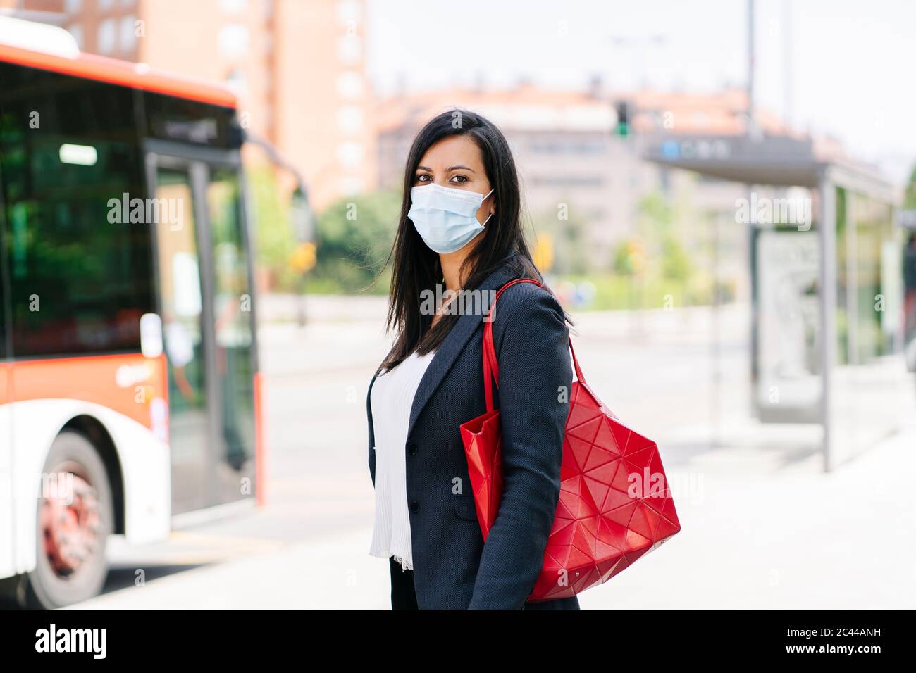Portrait einer Frau mit Schutzmaske an der Bushaltestelle, Spanien Stockfoto