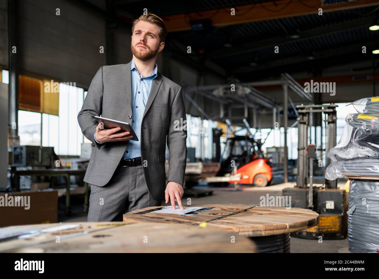 Junger Geschäftsmann mit Tablet in einer Fabrik Stockfoto