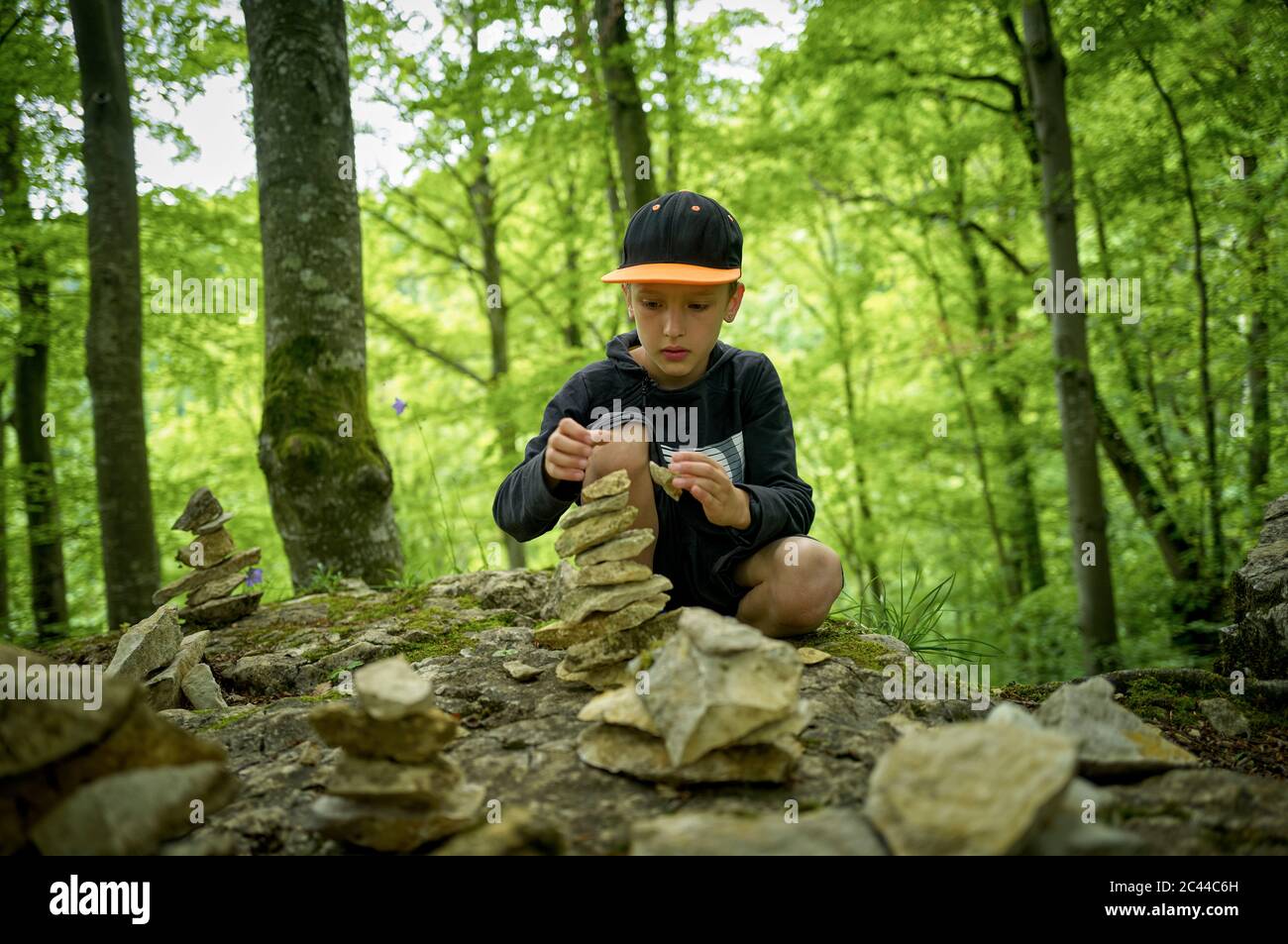 Junge stapelt Steine als Kairn im Schwäbischen Alb Wald Stockfoto