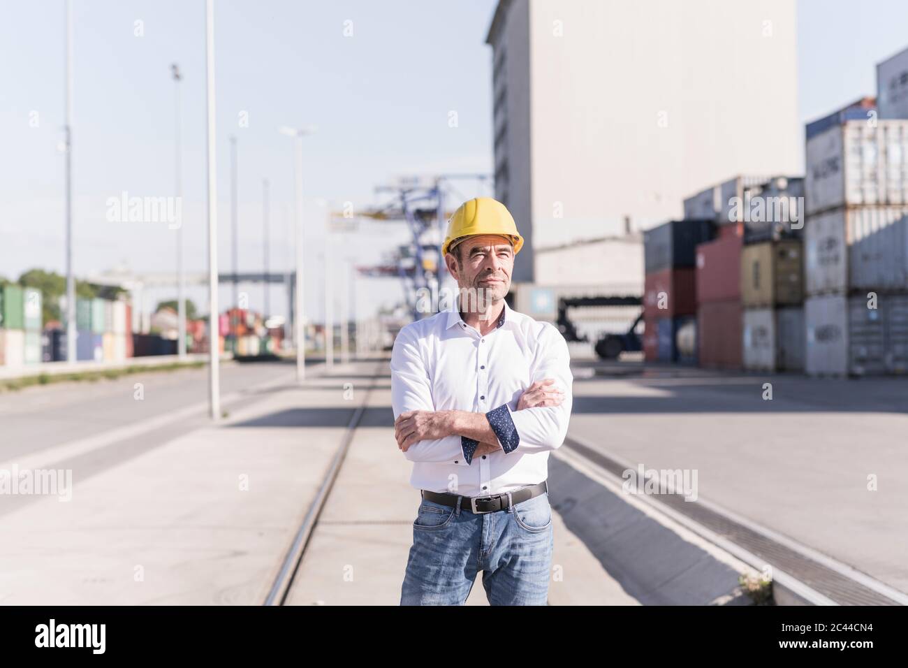 Porträt eines Geschäftsmannes mit Schutzhelm auf dem Industriegelände Stockfoto
