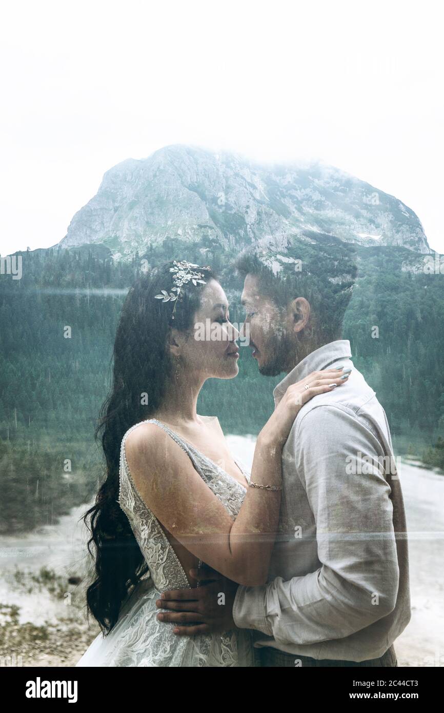 Der Bräutigam und die Braut umarmen und küssen sich auf dem Hintergrund des Sees. Hochzeit in der Natur. Doppelte Belichtung oder Overlay-Effekt. Stockfoto