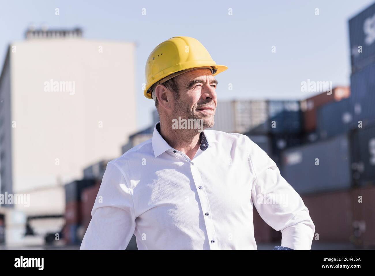Porträt eines Geschäftsmannes mit Schutzhelm auf Industriegelände Blick in der Ferne Stockfoto
