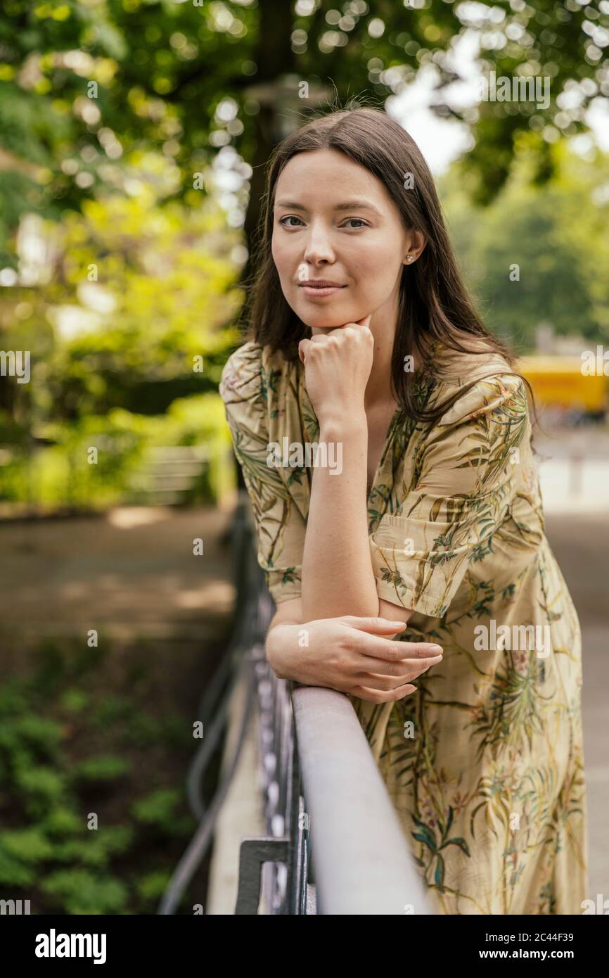 Porträt einer Frau, die sich auf das Geländer stützt Stockfoto