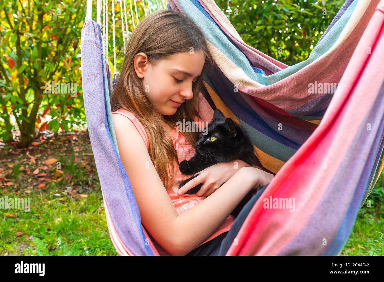 Portrait von Mädchen in der Hängematte kuscheln Katze Stockfoto