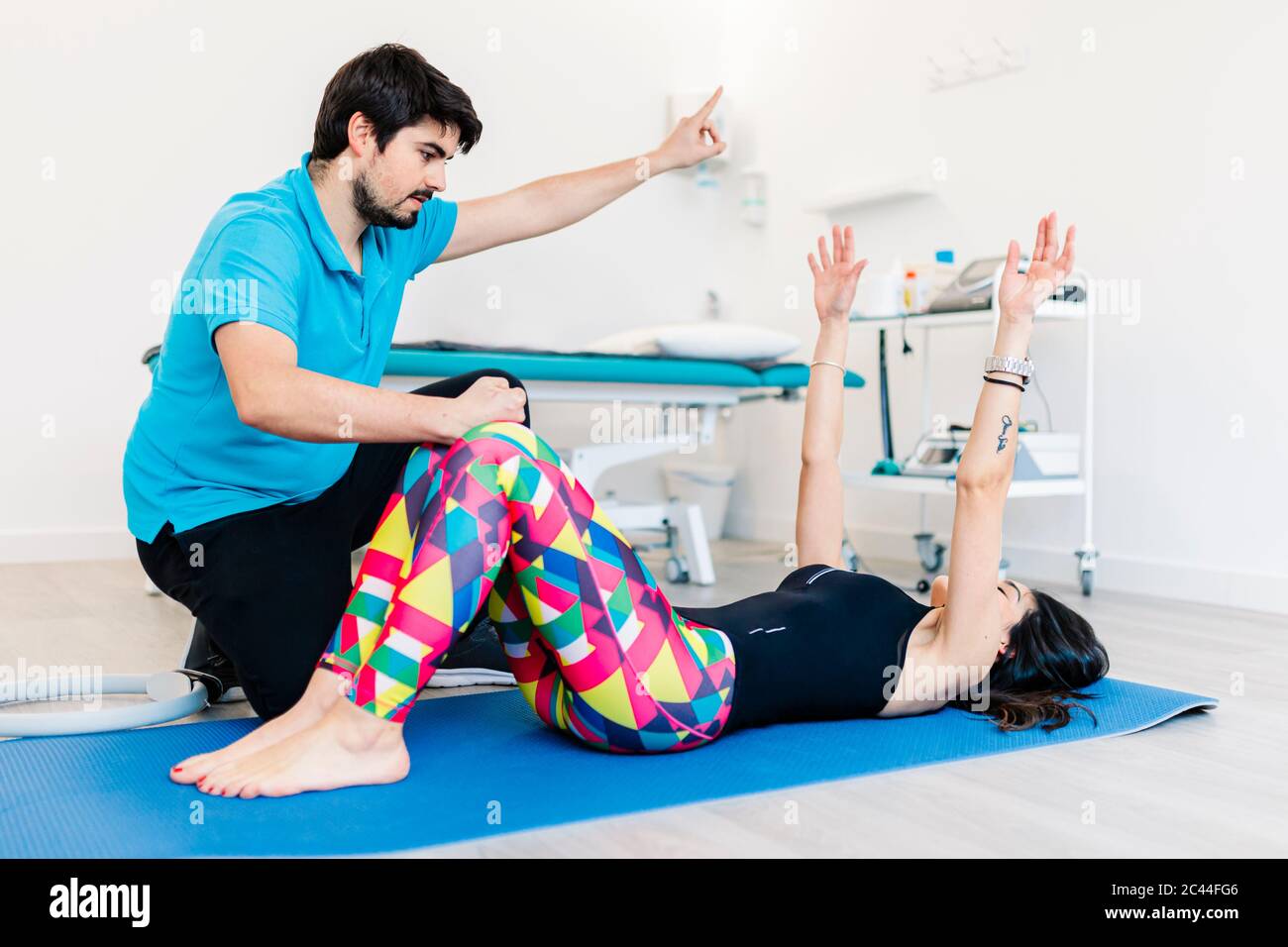 Sehbehinderte Physiotherapeutin, die Frau in Übungen in der Klinik unterrichtet Stockfoto