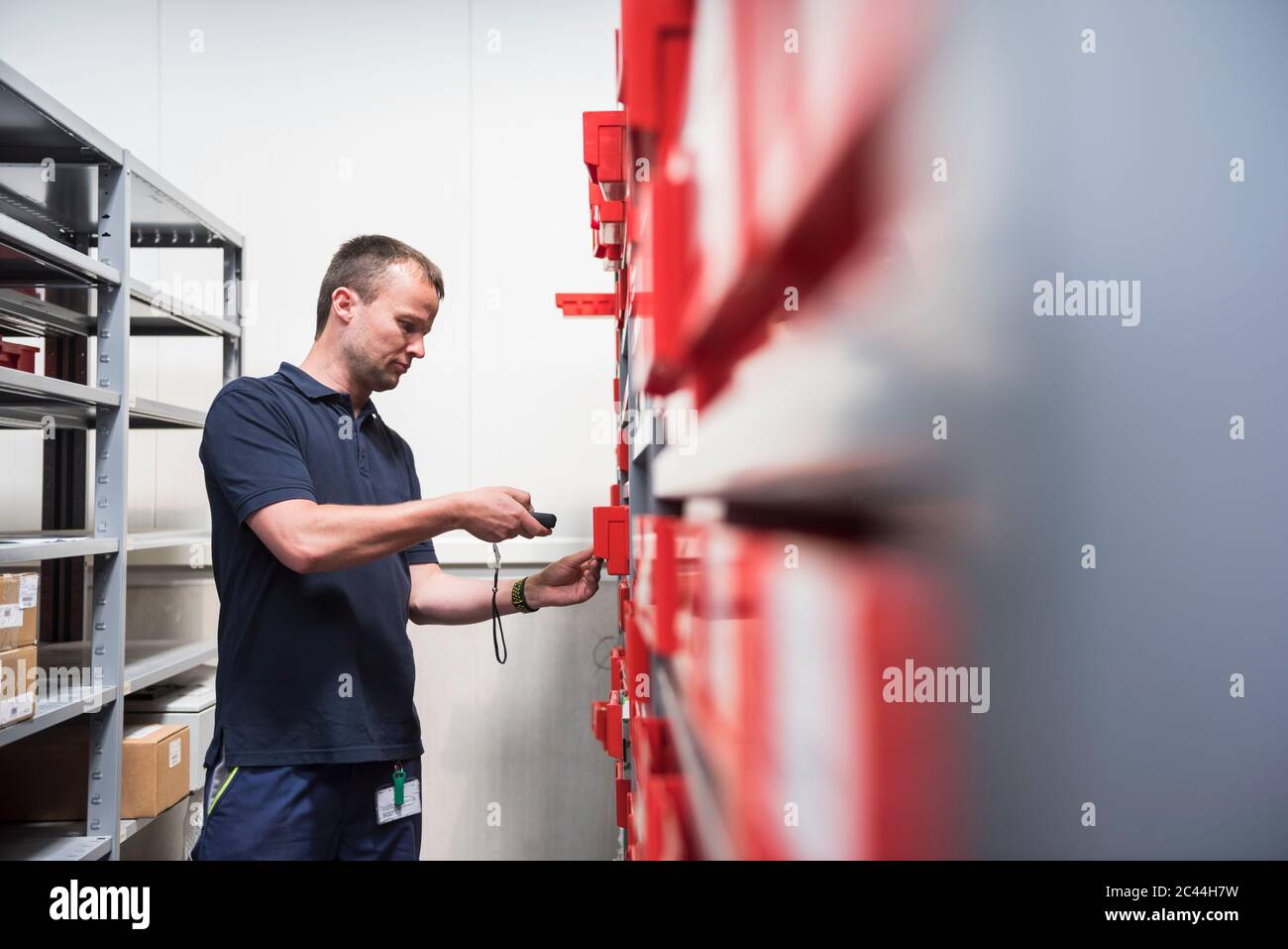 Mann im Lager einer Fabrik, der Waren scannt Stockfoto