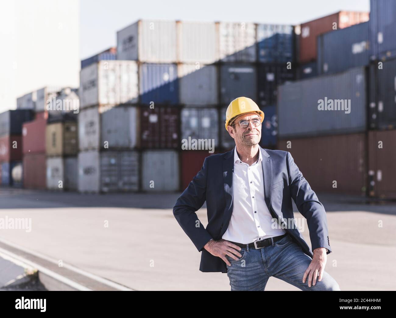 Porträt eines entspannten Geschäftsmannes mit Schutzhelm auf dem Industriegelände Stockfoto