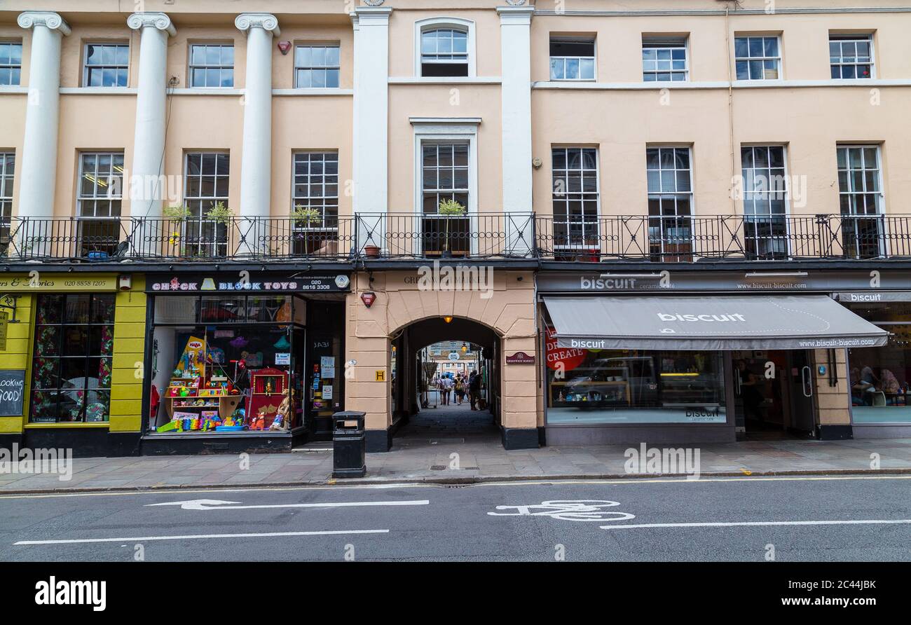 LONDON, Großbritannien - 21. JULI 2015: Gebäude und Geschäfte entlang der Nelson Road in London. Menschen können gesehen werden. Stockfoto