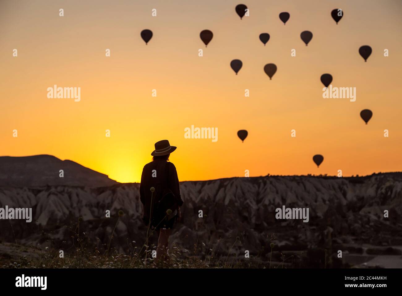 Ansicht der Rückseite des Silhouette junge Frau auf Heißluftballons, während auf dem Land in Göreme, Kappadokien, Türkei stehend Stockfoto