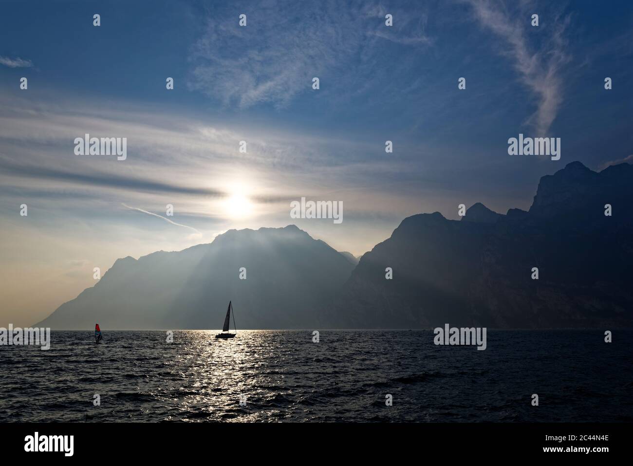 Italien, Trentino, Torbole, Gardasee umgeben von Bergen bei Sonnenuntergang Stockfoto