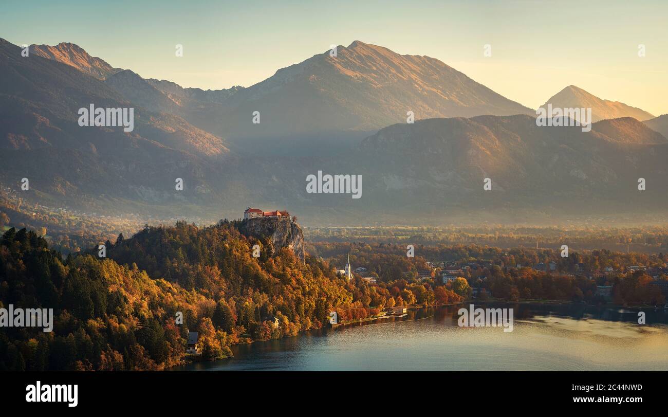 Slowenien, Oberkrain, Bled, Panorama der Burg Bled mit Blick auf die Stadt am Seeufer bei nebliger Morgendämmerung Stockfoto