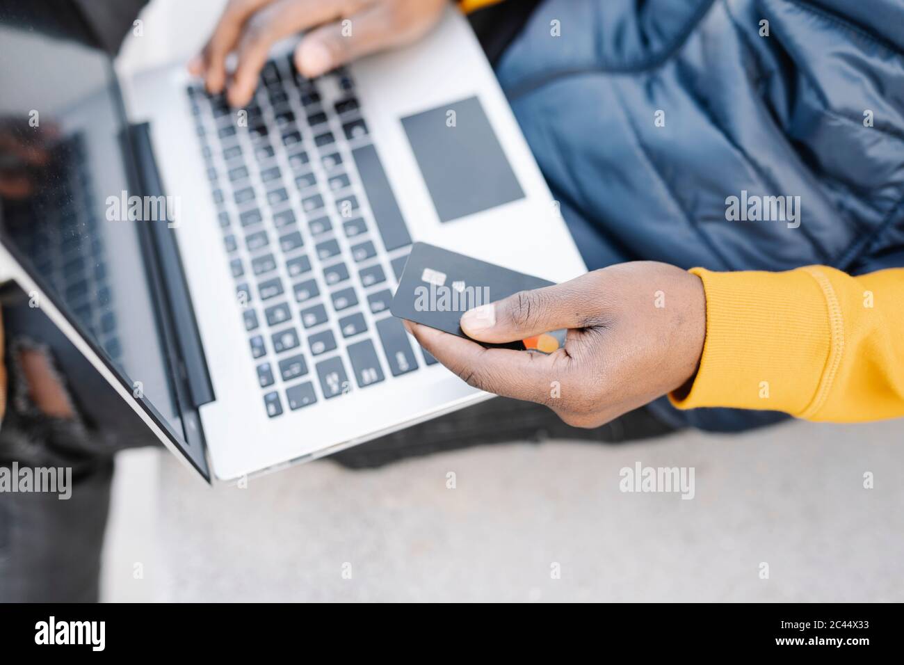 Nahaufnahme eines Mannes, der Laptop und Kreditkarte zum Online-Shopping verwendet Stockfoto