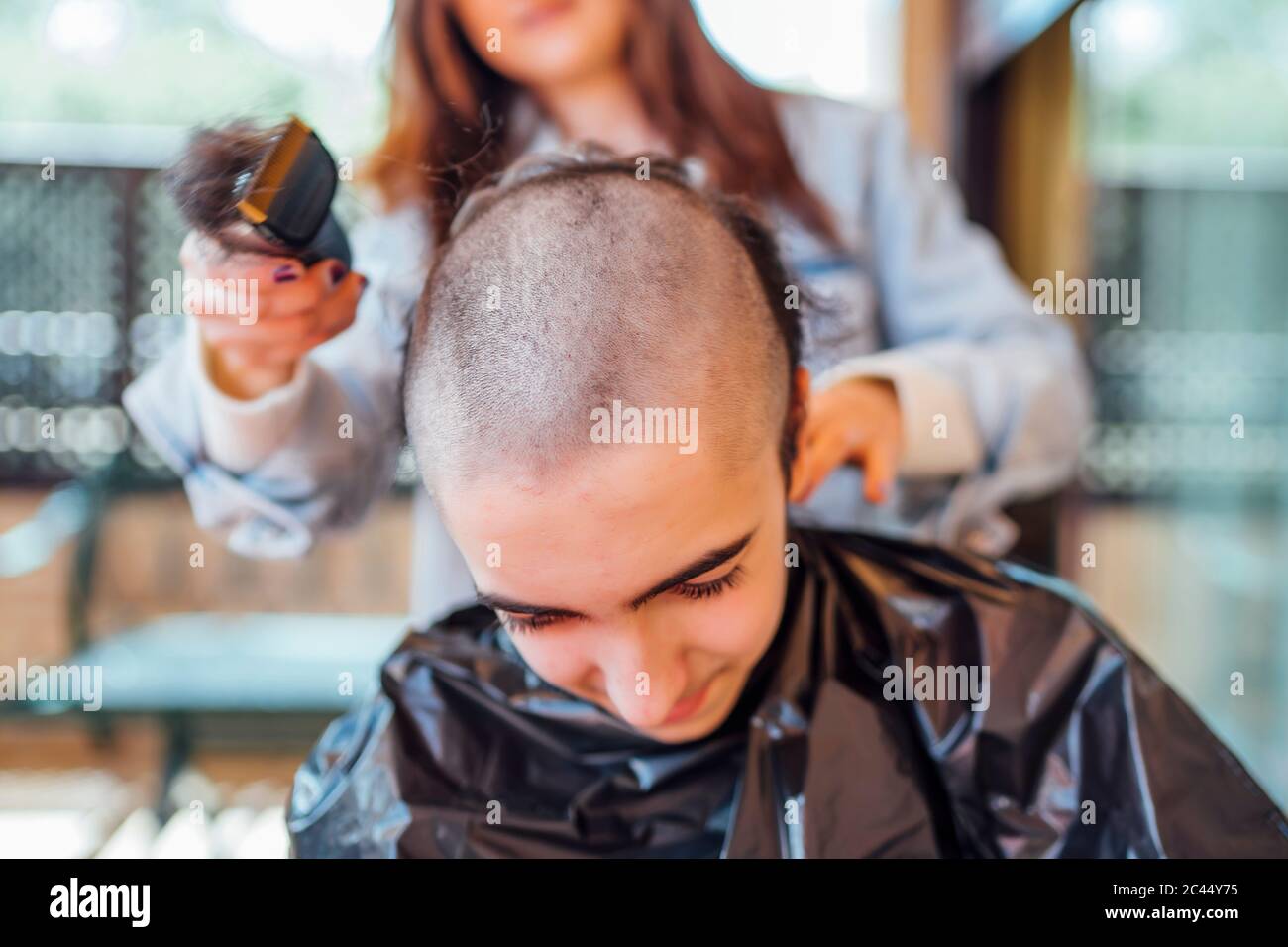 Mutter rasieren Teenager-Sohn den Kopf mit elektrischen Rasiermesser zu Hause Stockfoto