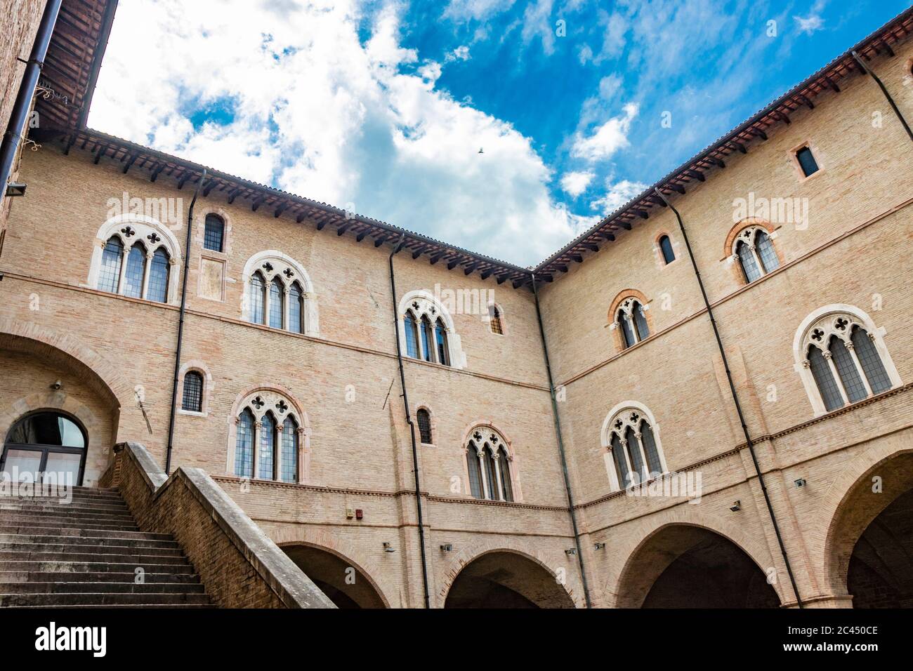 1. Juni 2019 - Foligno, Perugia, Umbrien, Italien - der Innenhof und die gotische Treppe des antiken Trinci Palastes. Ziegelmauer, Fenster, Bögen und Stockfoto