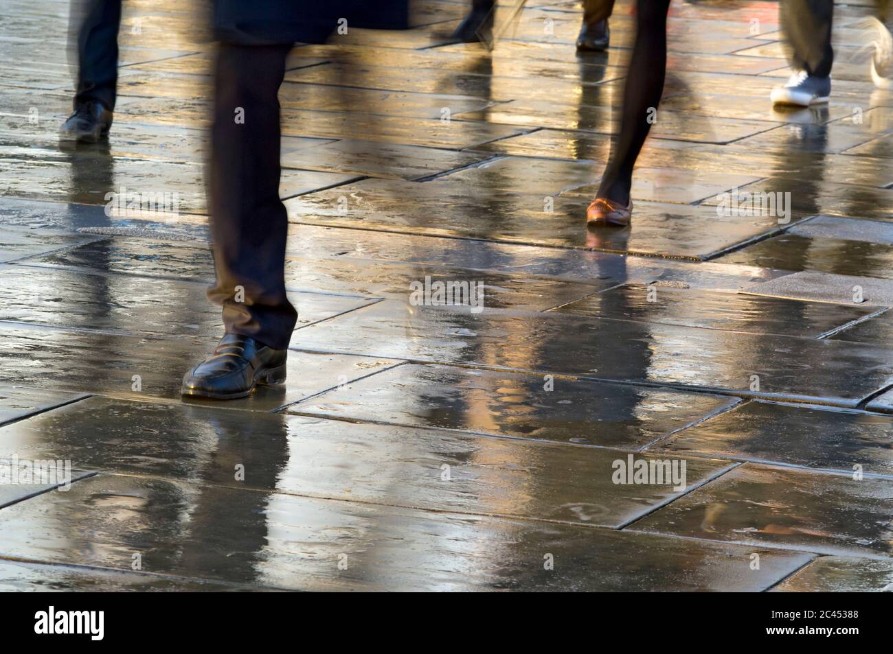Die Menschen gehen auf dem Bürgersteig im Regen, London, England Stockfoto