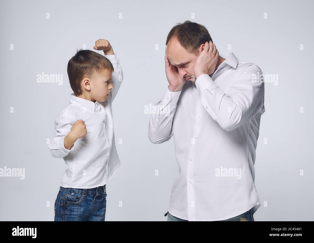 Der kleine Sohn dominiert den Vater. Vaterschaft, Psychologie der Beziehungen.Studio, White back Stockfoto
