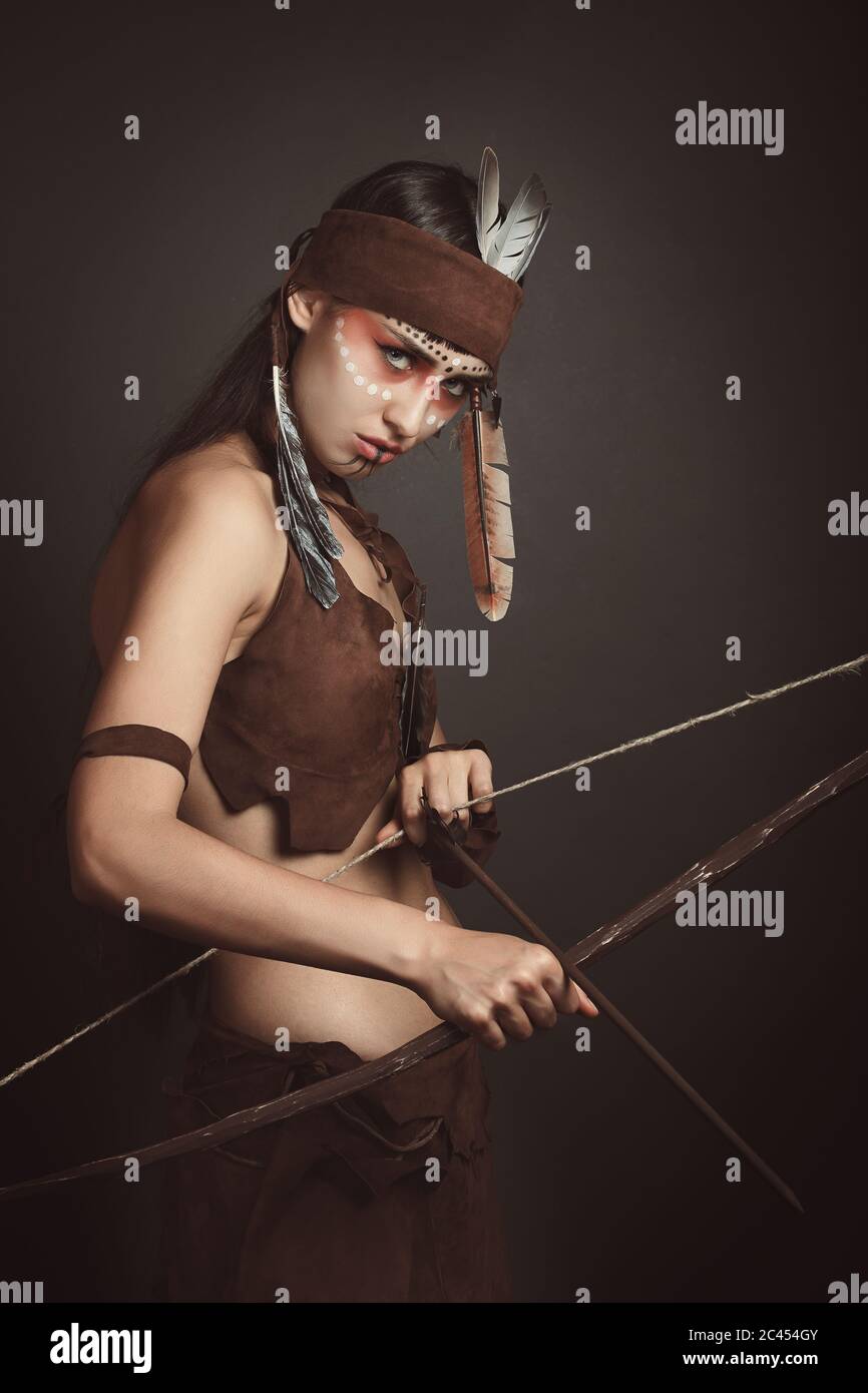 Wilder einheimischer Krieger mit Pfeil und Bogen. Studioaufnahme Stockfoto