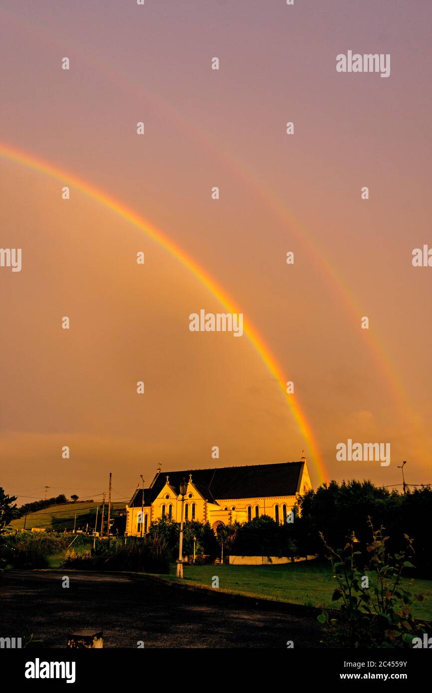 Doppelter Regenbogen bei Sonnenuntergang über der Kirche der Heiligen Familie, Ardara, County Donegal, Irland Stockfoto