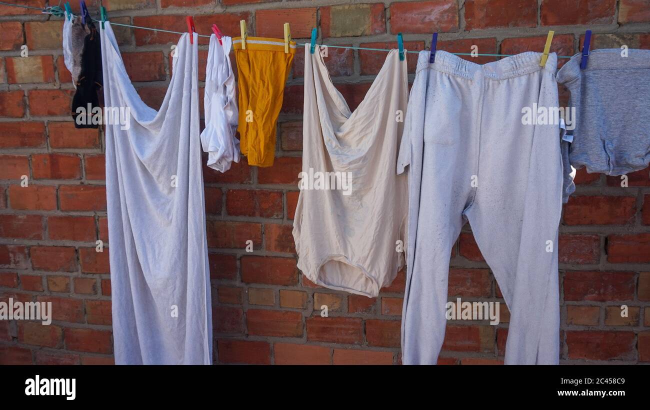 Bunte Kleidung hängt am Wäscheseil Stockfoto