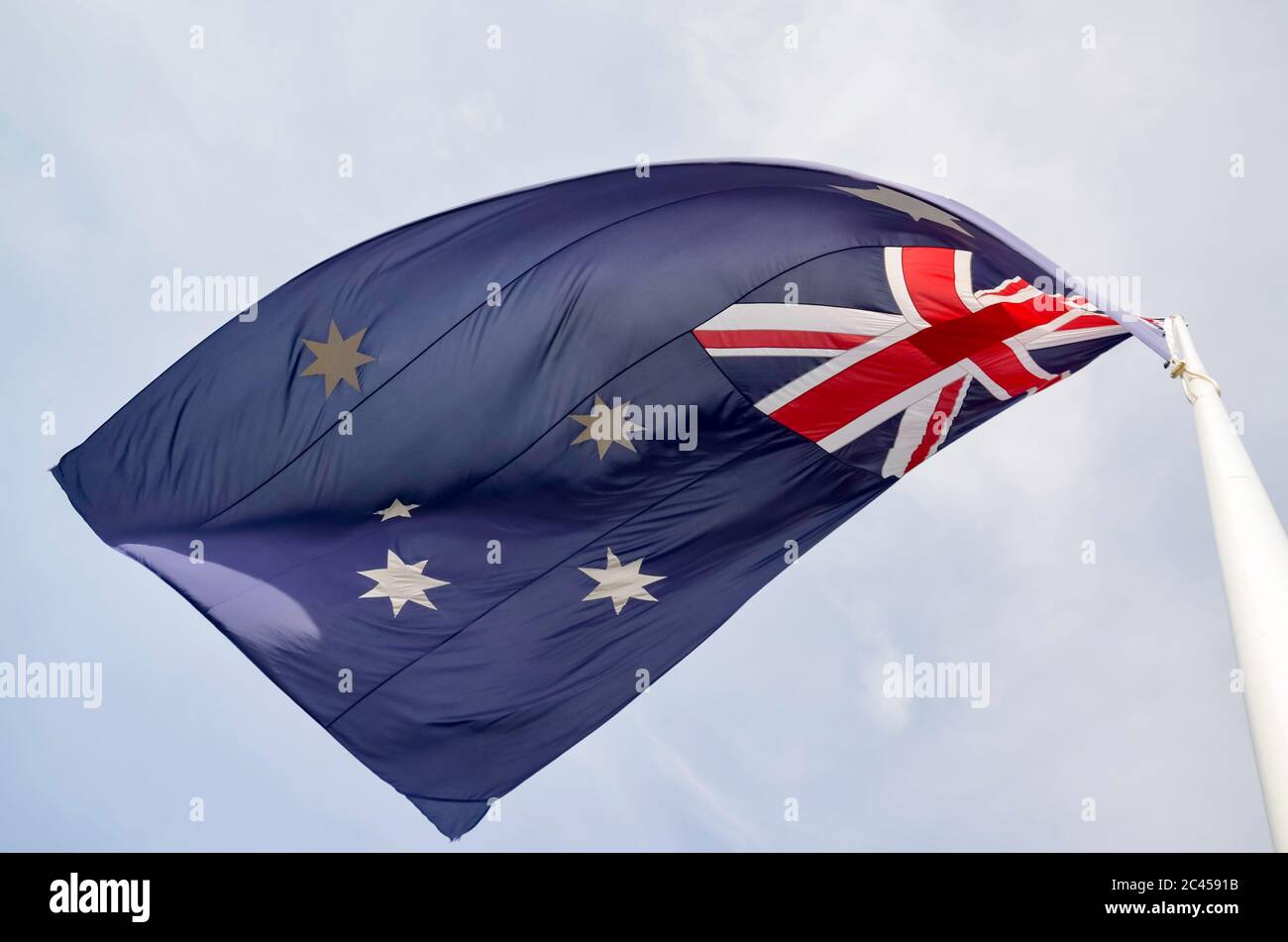 Von unten auf eine australische Flagge blicken, die auf einem Fahnenmast fliegt Stockfoto