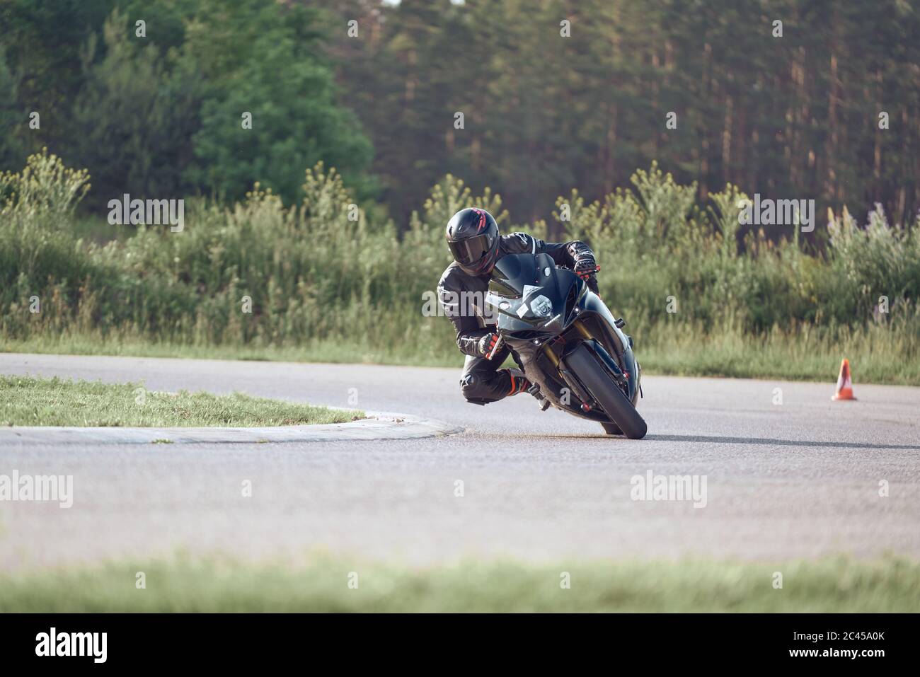 11-05-2020 Riga, Lettland. Motorbiker auf einer Rennstrecke, die um eine Ecke mit einem Rennkurs Bordstein hinter sich rast. Stockfoto